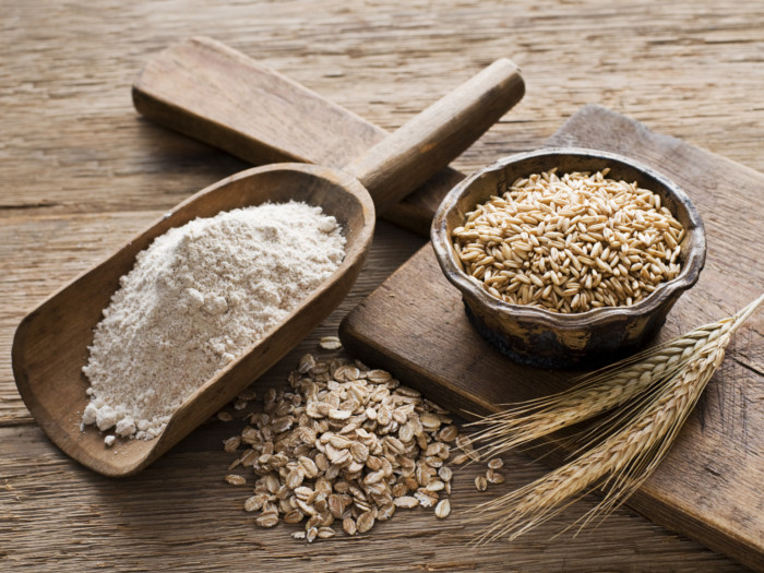 Un cucchiaio di farina, grano e avena su un tavolo