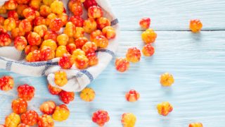 Scattered cloud berries on a cloth and some on the table