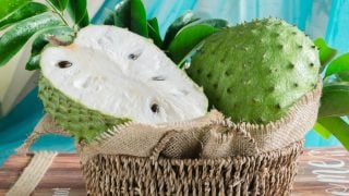 A basket filled with whole and sliced soursop